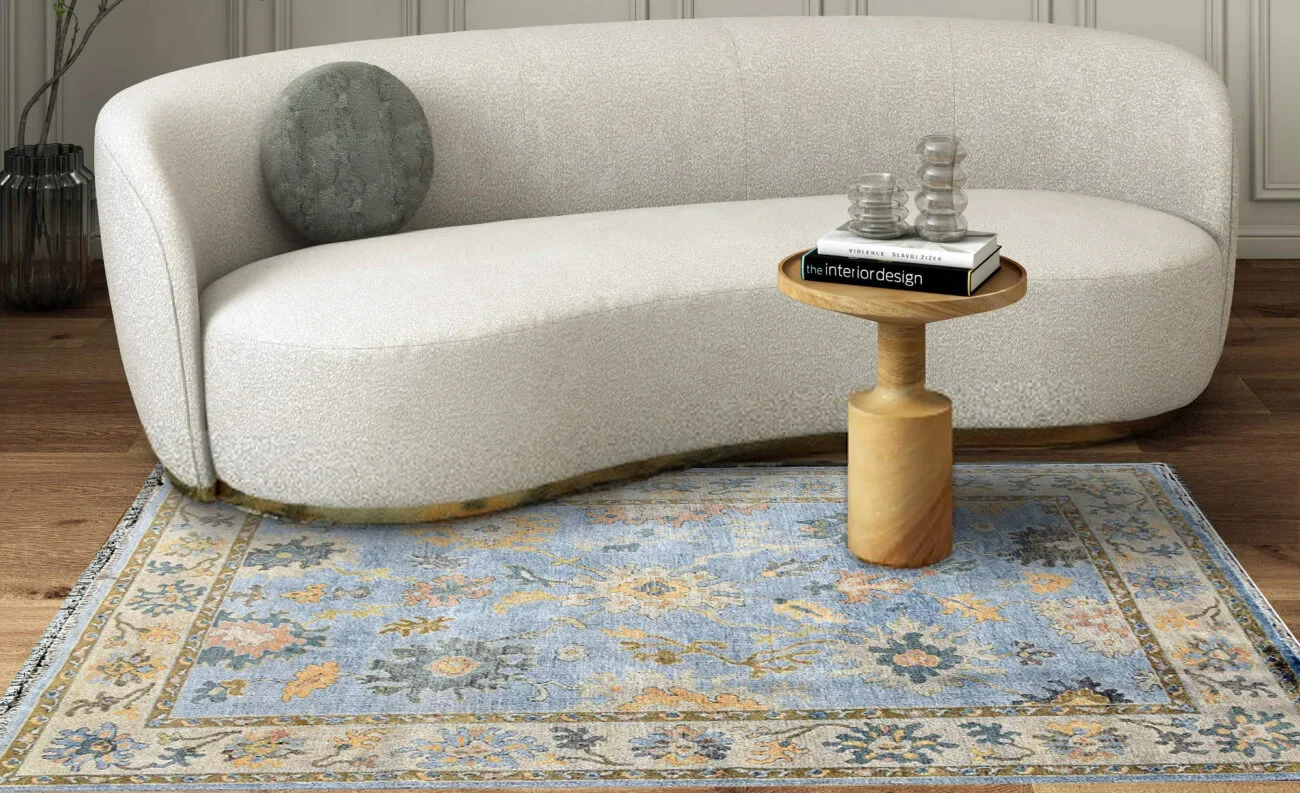 Soft blue and gold Oushak rug with delicate floral patterns in a formal setting.