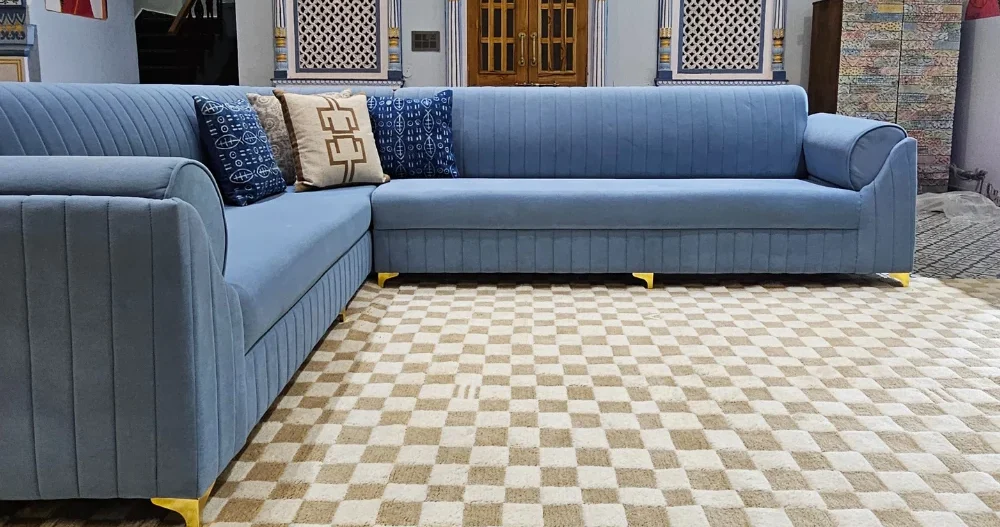 Beige and white checkered rug in a well-designed living space with blue sofas and intricate decor.